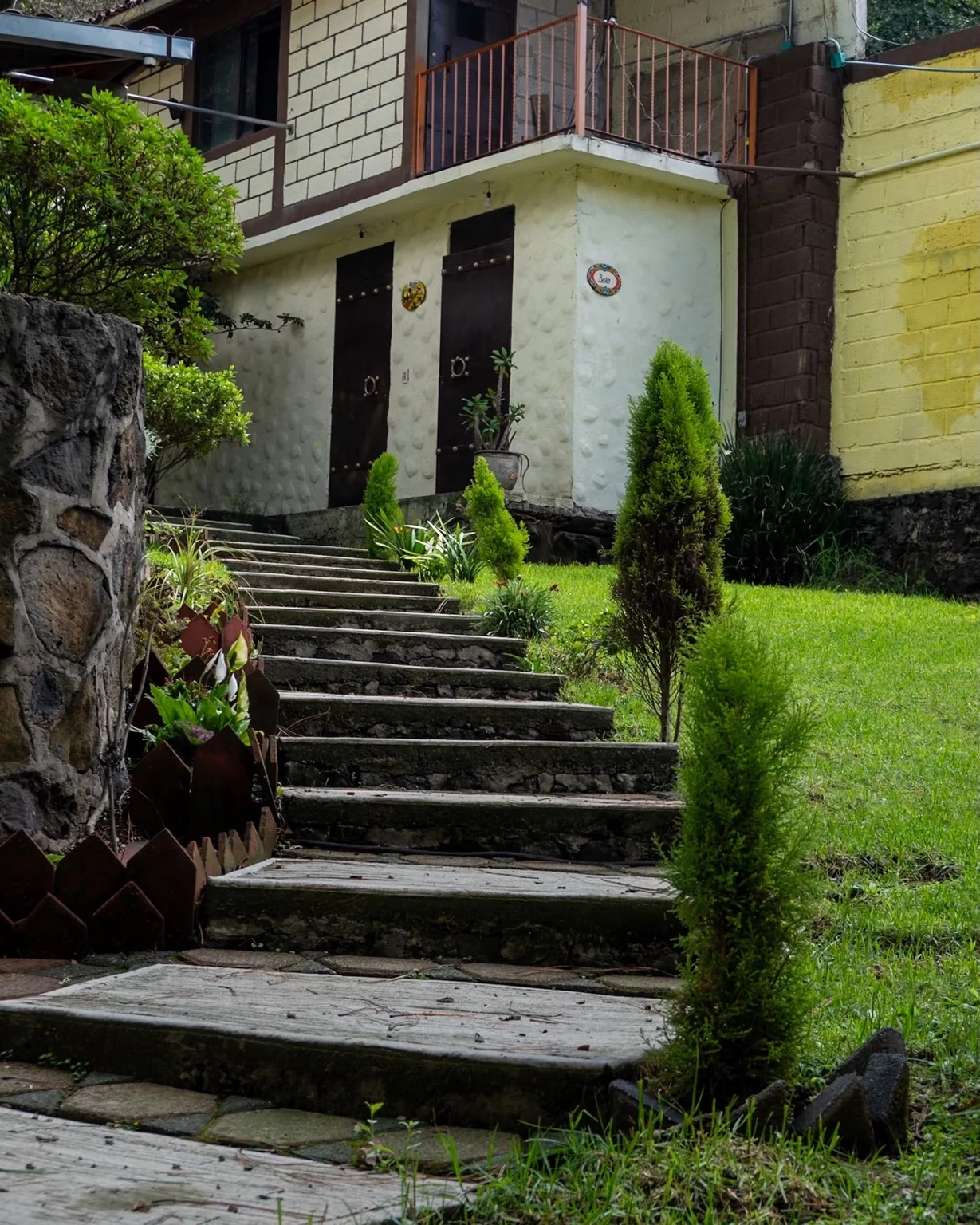 Jardín y escalinata de acceso entre vegetación